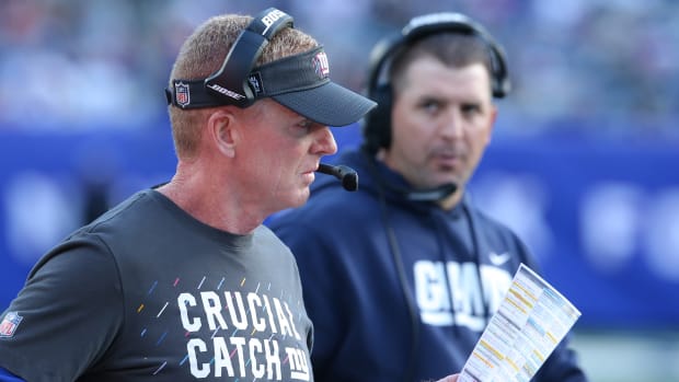 Giants offensive coordinator Jason Garrett looks at his play sheet with head coach Joe Judge in the background